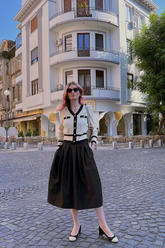 a lady wears a white cardigan with a black midi dress